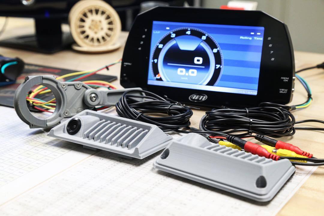 The MXG 7" Car Dash Display & Data Logger on a workbench in a garage