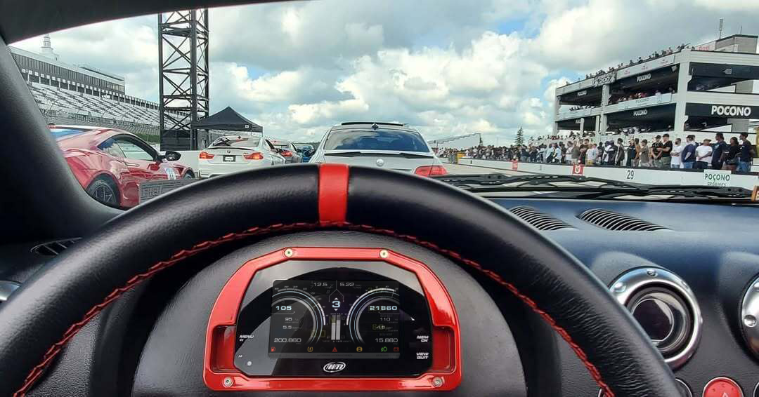 The MXS Strada 5" Display integrated into a car dashboard on a racetrack