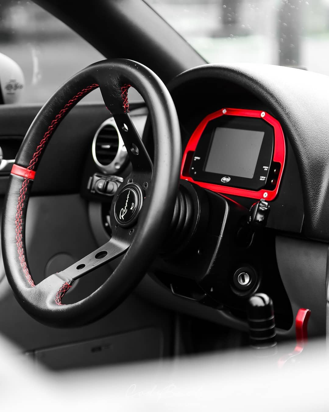 The MXSL 5" Display integrated into a car dashboard on a racetrack