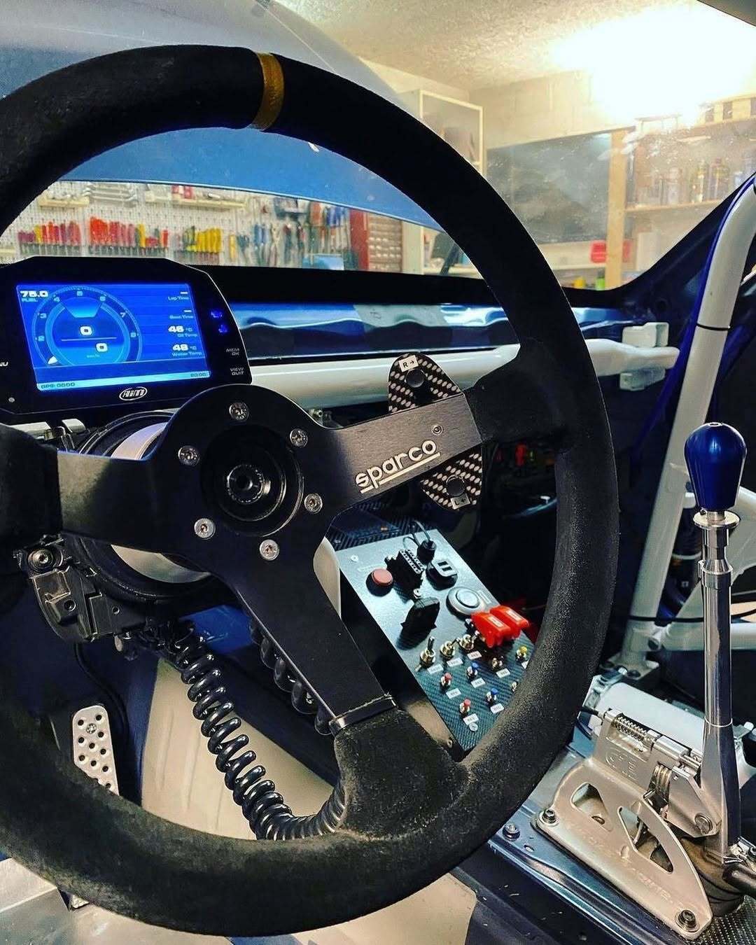 The MXS Strada Light 5" Display integrated into a car dashboard on a racetrack