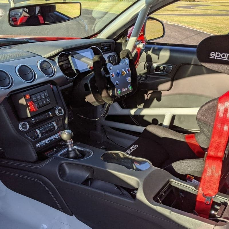 The MXP Strada 6 inch Display integrated into a car dashboard on a racetrack