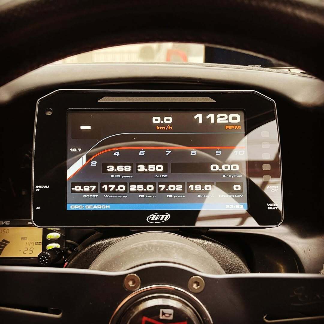 The MXP Strada 6 inch Display integrated into a car dashboard on a racetrack